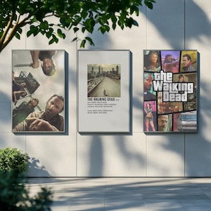 Puede incluir: Tres carteles enmarcados con imágenes de la serie "The Walking Dead". Los carteles se exhiben al aire libre contra una pared gris claro. Un cartel muestra un grupo de personajes, otro una escena de la ciudad y el tercero un collage de personajes.