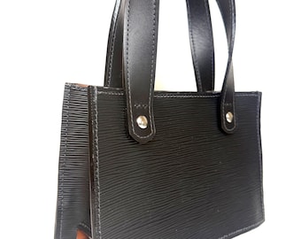 Bolso de noche de piel negra con textura ondulada.