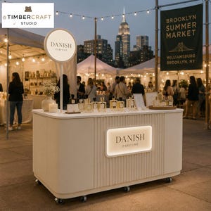 Peut inclure: Un comptoir de présentation mobile blanc et rectangulaire avec un panneau avant cannelé et une enseigne rétroéclairée indiquant DANISH PARFUME. Le comptoir comprend une enseigne circulaire assortie sur un mât, un vase et des flacons de parfum.