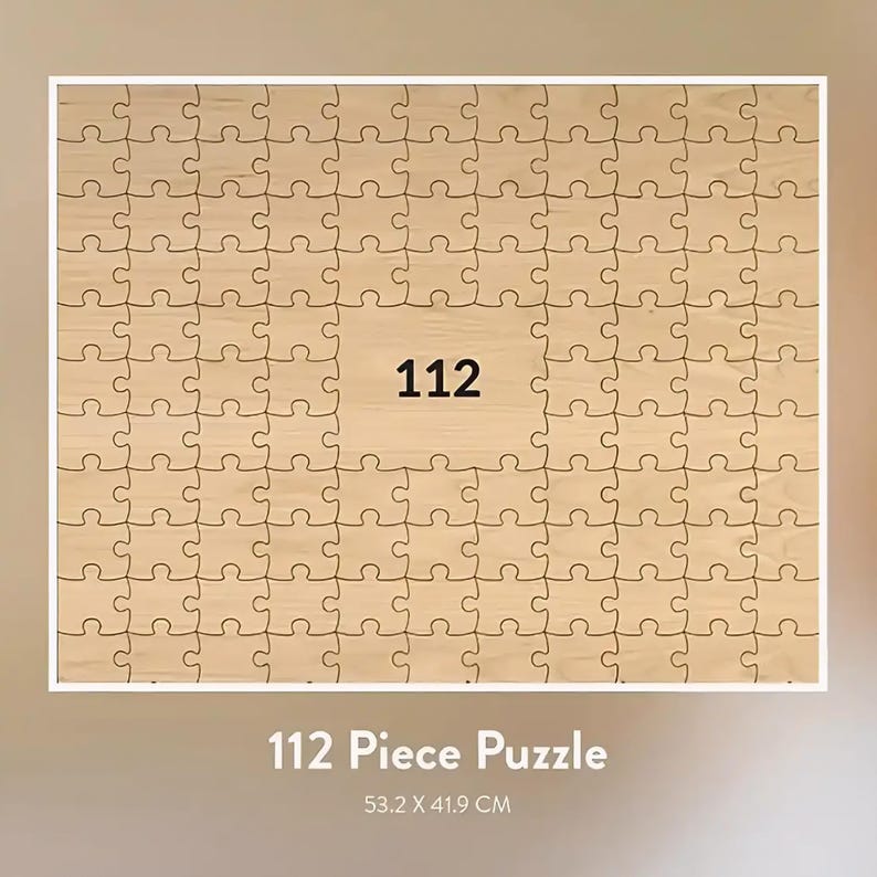 May include: A 112-piece wooden jigsaw puzzle with a light brown finish. The puzzle is rectangular and features a central square with the number "112" in black. The puzzle measures 53.2 x 41.9 cm.