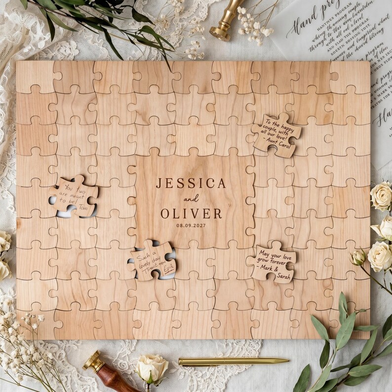 May include: A wooden puzzle guest book with the names "JESSICA and OLIVER" and the date "08.09.2027" engraved on it. Several puzzle pieces are missing, with handwritten notes on some. The puzzle is surrounded by floral decorations.