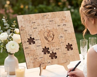 May include: A rectangular wooden jigsaw puzzle guest book featuring interlocking pieces with handwritten names. The center piece displays a heart icon with the initials S/M, the text SCOTT & MELODY, and the date 08/08/2022. Several pieces are missing.