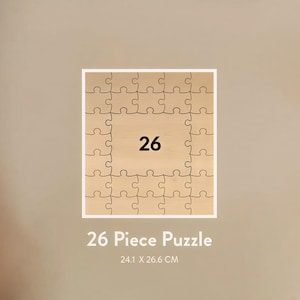 May include: A 26-piece wooden puzzle with a light brown finish. The puzzle is square, with a white border and the number 26 in the center. The text "26 Piece Puzzle" and dimensions 24.1 x 26.6 CM are below the puzzle.