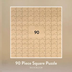 May include: A 90-piece square puzzle with a light wood grain finish. The number 90 is prominently displayed in the center. The puzzle measures 53.2 x 34.2 cm.