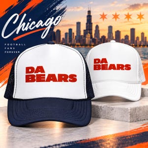 May include: Two trucker hats featuring white front panels with the red text DA BEARS. One hat has a navy blue brim and mesh back, while the other is entirely white. The background displays a Chicago skyline graphic with the text Chicago Football Fans Forever.