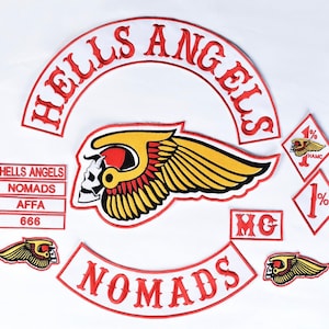 May include: A collection of embroidered patches featuring a large arched HELLS ANGELS top rocker, a central winged skull emblem, a NOMADS bottom rocker, and smaller patches including 1% diamonds, MC, AFFA, 666, and additional winged skull motifs.