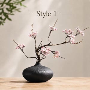 Zen-stil konstblomsterarrangemang, svart keramisk vas, minimalistisk heminredning