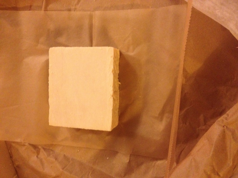 May include: A rectangular bar of soap wrapped in brown paper.