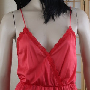 May include: A red satin slip dress with lace trim around the neckline.