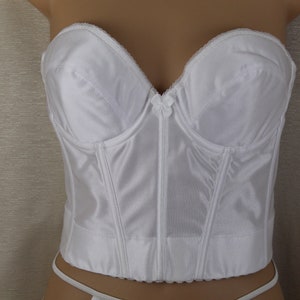 Op de afbeelding: Witte strapless bh met beugels en een haak- en oogsluiting aan de achterkant.