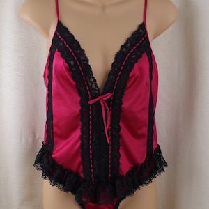 May include: A red satin teddy with black lace trim and a bow at the neckline.