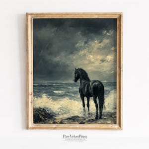 May include: A framed wall art print featuring an oil painting of a black horse standing in the surf of a turbulent ocean under a dark, stormy sky. The frame is a light-toned wood with a visible grain, and the text Paw Velvet Prints is below.