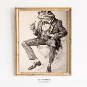 May include: A framed black and white ink drawing of a frog with a human body sitting on a toilet. The frog wears a three-piece suit with a bow tie and holds a small spoon. A pocket watch is visible on the vest. Text at the bottom reads PawVelvetPrints.