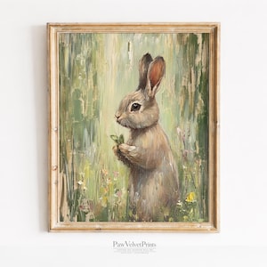 Pode incluir: Pintura emoldurada em estilo vintage de um coelho em um campo. O coelho é marrom e cinza, segurando folhas verdes. O fundo é uma mistura de pinceladas verdes e amarelas, com pequenas flores.