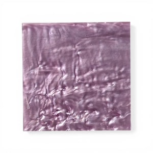 Peut inclure: Une plaque carrée en acrylique irisée de couleur lavande. La surface présente un motif tourbillonnant et texturé avec un éclat nacré. Les bords sont nets et le matériau semble solide.