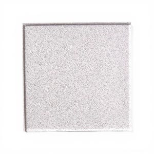 Könnte beinhalten: Eine quadratische, transparente Glasfliese mit einem glitzernden, silbern gesprenkelten Design. Die Fliese hat eine glatte, reflektierende Oberfläche und ist vor einem weißen Hintergrund platziert. Die Kanten der Fliese sind sauber und gerade.