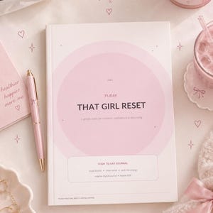 May include: A white journal with a large light pink circle on the cover, featuring the text 75-DAY THAT GIRL RESET, a gentle reset for routines, confidence & becoming, and YOUR 75-DAY JOURNAL. The cover includes small star and heart icons.