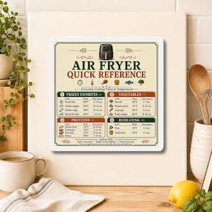 May include: A rectangular kitchen magnet featuring an air fryer quick reference guide with cooking times and temperatures for frozen favorites, vegetables, proteins, and reheating. The chart includes small icons and text in dark green and brown.