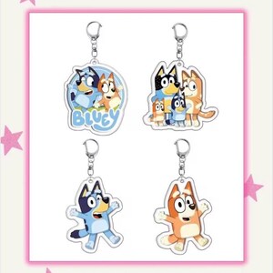 May include: Four acrylic keychains featuring characters from the animated series Bluey. Each keychain has a silver keyring. The keychains are in a pink frame with pink star decorations. The text "Ideas for your next diy project... Keychains" is at the bottom.