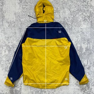 May include: A yellow and navy blue hooded jacket with long sleeves and a drawstring hood. White measurement lines and numbers indicate a length of 83 cm, a shoulder width of 50 cm, a chest width of 64 cm, and sleeve lengths of 76 cm and 58 cm.