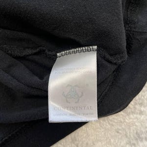 May include: Close-up of a black garment with a white tag. The tag features the text "RESPONSIBLY SOURCED FOR BRANDS WHO CARE" and the brand name "CONTINENTAL" with locations: London, Berlin, Tokyo.