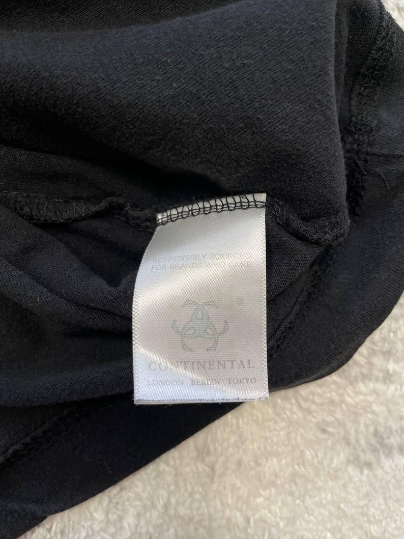 May include: Close-up of a black garment with a white tag. The tag features the text "RESPONSIBLY SOURCED FOR BRANDS WHO CARE" and the brand name "CONTINENTAL" with locations: London, Berlin, Tokyo.