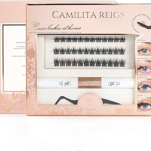 Könnte beinhalten: Ein rosa Box-Set mit falschen Wimpern mit dem Text "CAMILITA REIGN" und "Luxe lashes at home". Das Set enthält Wimpern, Kleber und eine Pinzette. Die Box hat ein Blumendesign und Anwendungsanweisungen.
