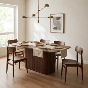 Può includere: Una sala da pranzo moderna con un tavolo ovale in legno scuro e sei sedie abbinate. Il tavolo è apparecchiato con piatti, posate e un runner beige. Un lampadario in ottone è appeso sopra il tavolo e un'opera d'arte astratta incorniciata è sulla parete.