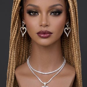 May include: A mannequin head with long, blonde braided hair, wearing a diamond necklace with a heart pendant and matching heart-shaped earrings. The mannequin also has full makeup and the text "LUXURY WIGSY LADY-D HIGH-END CUSTOM WIGS" on a black and gold sticker.