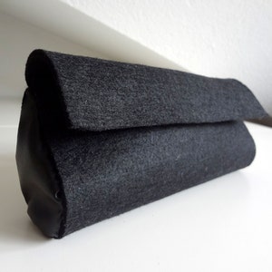 Felt black clutch with faux leather details for a minimalist style
