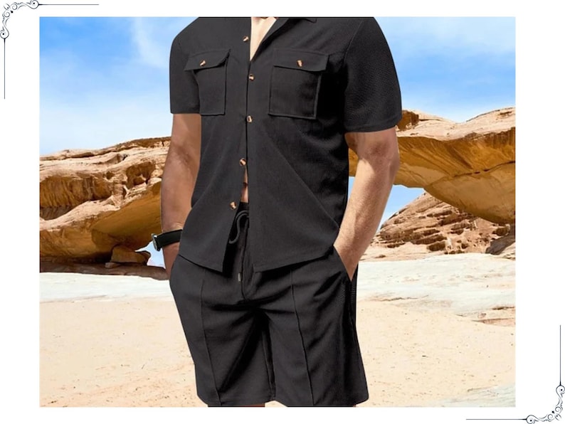 May include: Black short-sleeved shirt and matching shorts. The shirt has two chest pockets and button closures. The shorts have a drawstring waist and vertical seams. The outfit is made of a textured fabric. The background shows a desert landscape.