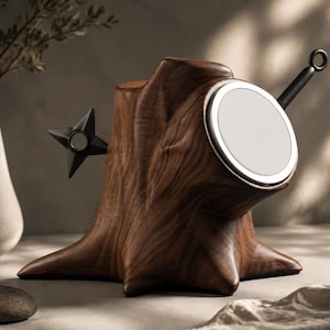 Peut inclure: Une sculpture en bois brun foncé en forme de souche d'arbre, dotée d'un luminaire circulaire blanc encastré à l'avant, d'un objet noir en forme d'étoile à quatre branches sur le côté gauche et d'une poignée noire avec un anneau à l'extrémité.