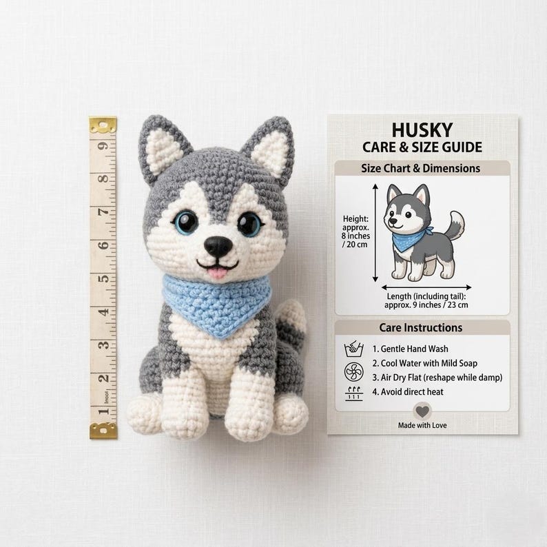 Pode incluir: C&atilde;o husky de croch&ecirc; com detalhes cinza, branco e azul. O brinquedo de pel&uacute;cia tem olhos azuis e uma bandana azul. A altura &eacute; de aproximadamente 20 cm e o comprimento de aproximadamente 23 cm. Um guia de cuidados est&aacute; inclu&iacute;do.