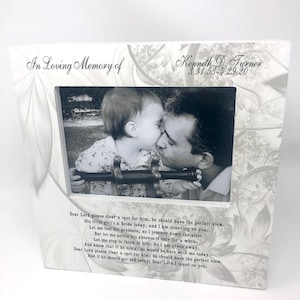 May include: A white picture frame with a black and white photo of a father and daughter kissing. The frame has a white background with a floral design and the text "In Loving Memory of Kenneth D. Turner 3.31.53-4.29.20". The frame also includes a poem about remembering a loved one.