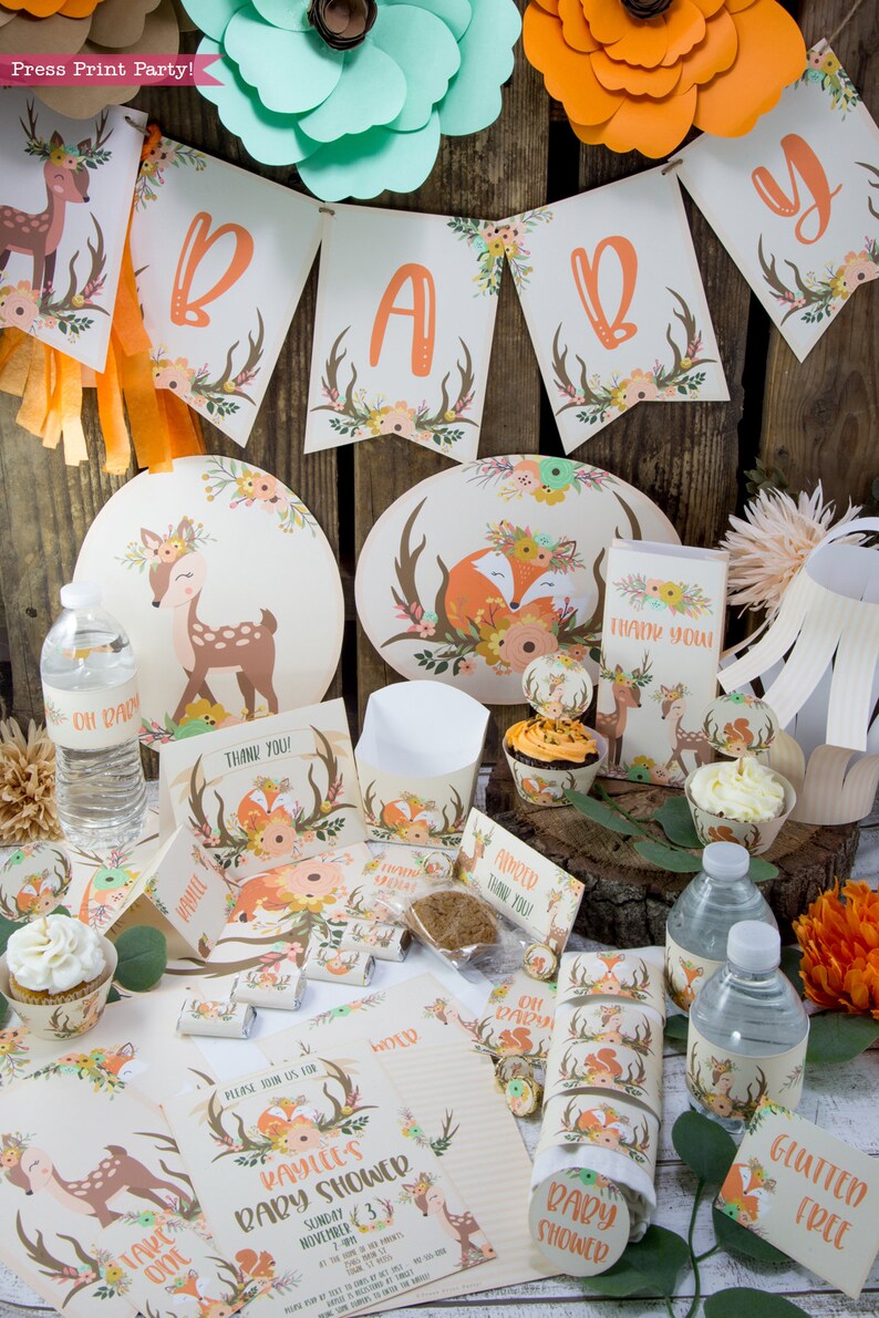 May include: A woodland themed baby shower party set with a fawn and fox design. The set includes plates, cups, napkins, favors, and decorations. The colors are orange, brown, and green.