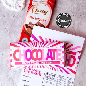 May include: A Valentine's Day-themed image featuring a dark chocolate bar, a decorative white heart, and a greeting card. The chocolate bar is red with the brand name "Choceur" and the words "Dark Chocolate". The card says "Chocolate" and "Happy Valentine's Day!"