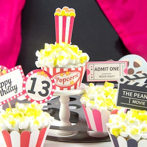 May include: A set of movie-themed cupcakes decorated with popcorn and topped with various printable toppers, including "Happy Birthday", "13", "Popcorn", "Admit One Movie Night", "The Peanut Movie", and "Movie Night!"