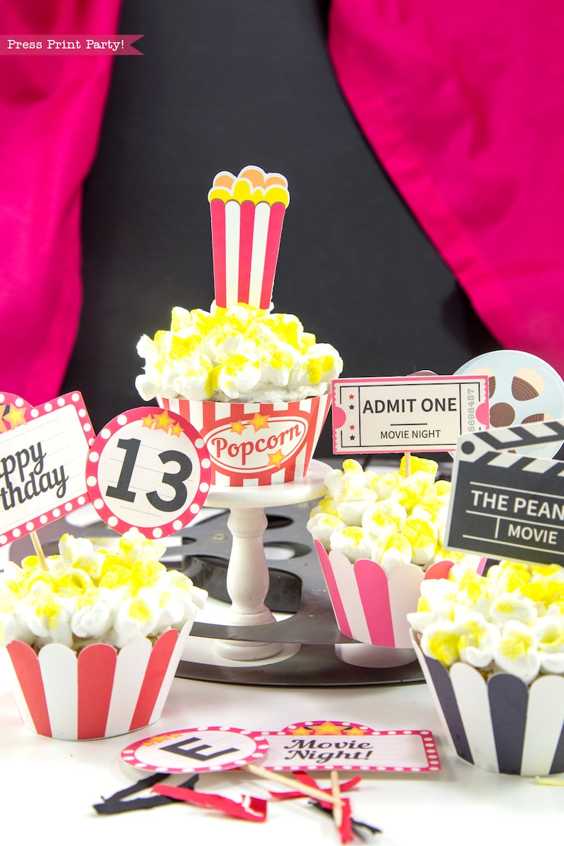 May include: A set of movie-themed cupcakes decorated with popcorn and topped with various printable toppers, including "Happy Birthday", "13", "Popcorn", "Admit One Movie Night", "The Peanut Movie", and "Movie Night!"