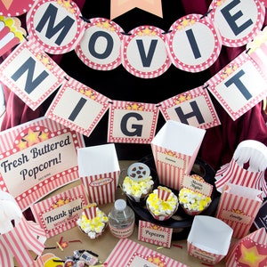 Op de afbeelding: Een filmnacht-feestset met rood-wit gestreepte papieren artikelen. De set bevat een banner met de tekst "Filmnacht", popcorn-dozen, cupcake-verpakkingen en een ticket-uitnodiging. De uitnodiging zegt "Filmnacht" en heeft een ster-ontwerp.