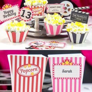 May include: A set of movie-themed cupcake toppers and popcorn boxes. The toppers feature a popcorn bucket, a movie ticket, a film reel, and a sign that says "The Peanuts Movie". The popcorn boxes are red and white striped with a popcorn design and a pink and white striped box with the name "Sarah" on it.