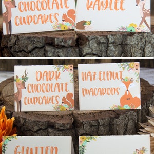 May include: Four printable food labels with a woodland theme. The labels feature a deer and a fox with floral accents. The text on the labels reads "Dark Chocolate Cupcakes", "Hazelnut Macarons", "Gluten Free", and "Kaylee".