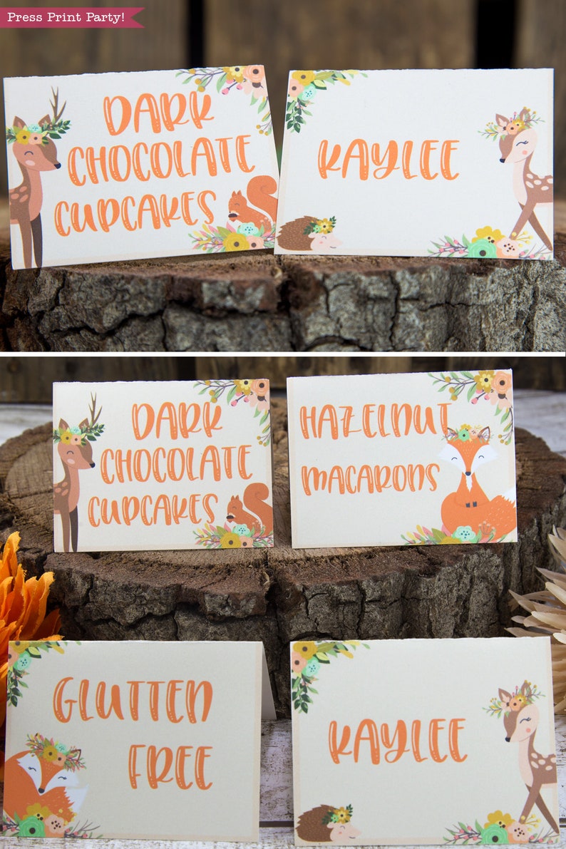 May include: Four printable food labels with a woodland theme. The labels feature a deer and a fox with floral accents. The text on the labels reads "Dark Chocolate Cupcakes", "Hazelnut Macarons", "Gluten Free", and "Kaylee".