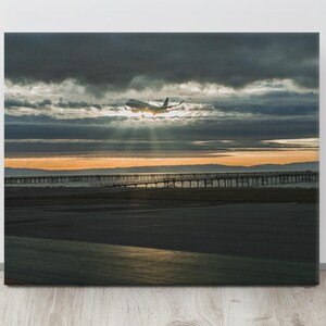 Toile San Francisco avion atterrissant à travers les nuages coucher de soleil | Photographie de ciel dramatique | Photo d'approche de la piste | Grande toile d'art murale