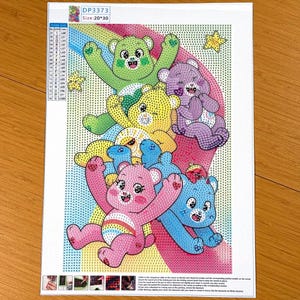 May include: A diamond painting kit canvas featuring five colorful cartoon bears in green, yellow, purple, pink, and blue, arranged over a rainbow background with two yellow stars. The canvas includes a color list, code DP3373, and size 20x30.