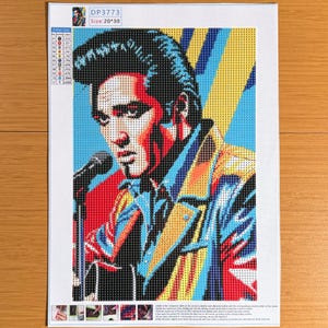 Puede incluir: Un kit de pintura de diamantes con un retrato estilo pop art de Elvis Presley cantando ante un micrófono. La imagen utiliza una paleta vibrante de rojo, amarillo y azul. El lienzo incluye una leyenda de colores, el texto DP3773 y tamaño 20*30.