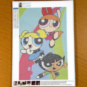 May include: A diamond painting kit featuring the Powerpuff Girls with the text DP3377 and Size: 20*30. The canvas displays a grid of symbols and colors depicting three characters with large eyes, blonde, orange, and black hair, on a patterned background.