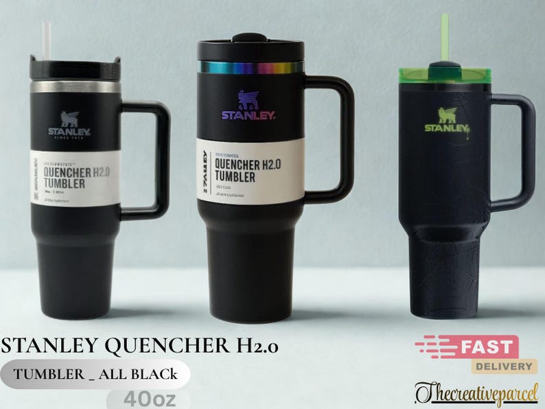 May include: Three black Stanley Quencher H2.0 tumblers with handles and straws. The two left tumblers feature white product labels reading Quencher H2.0 Tumbler. The center tumbler has an iridescent rim, and the right tumbler has a green lid.