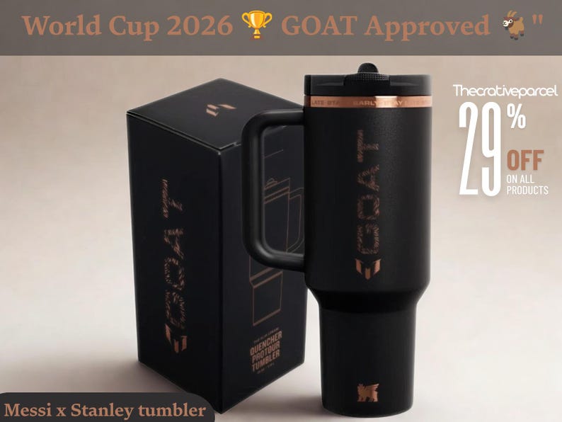 May include: A matte black insulated tumbler with a handle and a black lid, featuring the word GOAT in metallic copper lettering on the side. The tumbler is displayed next to its matching black box, which also features the GOAT logo in copper.
