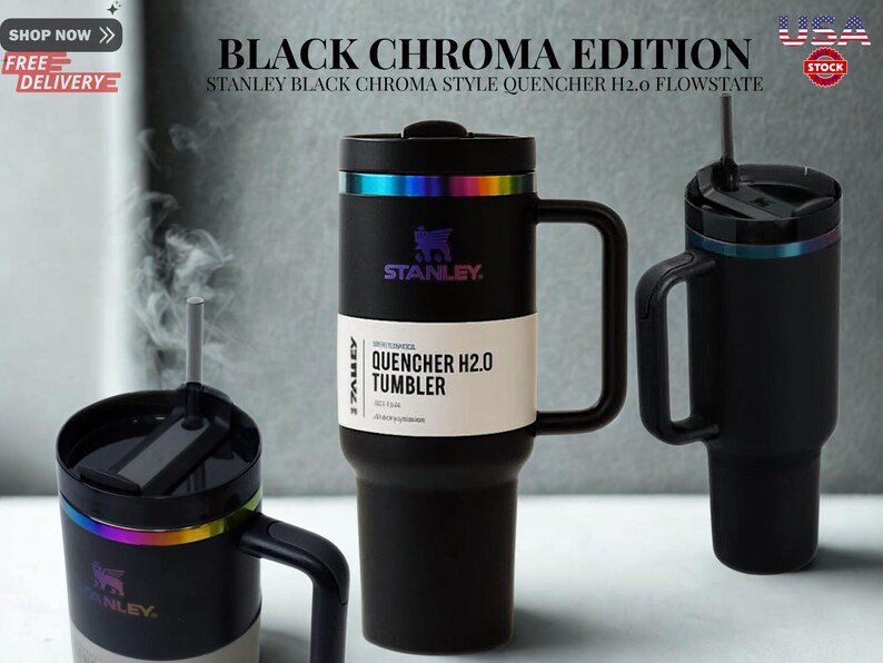 May include: Three matte black Stanley Quencher H2.0 Flowstate tumblers with iridescent rainbow-colored rims. The central tumbler features a white paper band with the text 'QUENCHER H2.0 TUMBLER' and a black handle. One tumbler shows steam rising.