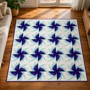 May include: A large, square quilt with a repeating pattern of stylized pinwheels in shades of deep purple, light blue, and white. The quilt has a white background and a dark purple border. The pinwheels are arranged in a grid.